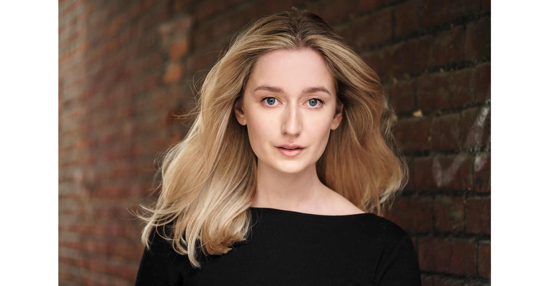 Blonde actress headshots portrait front of a brick wall in natural light